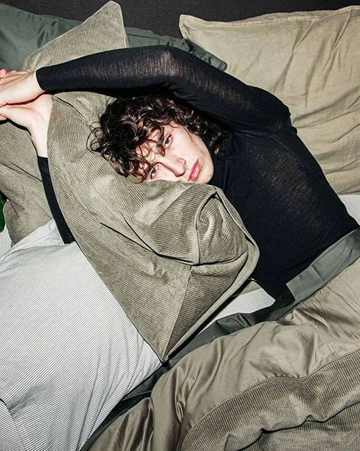 A person wrapped in olive bedding from The Sheet Society