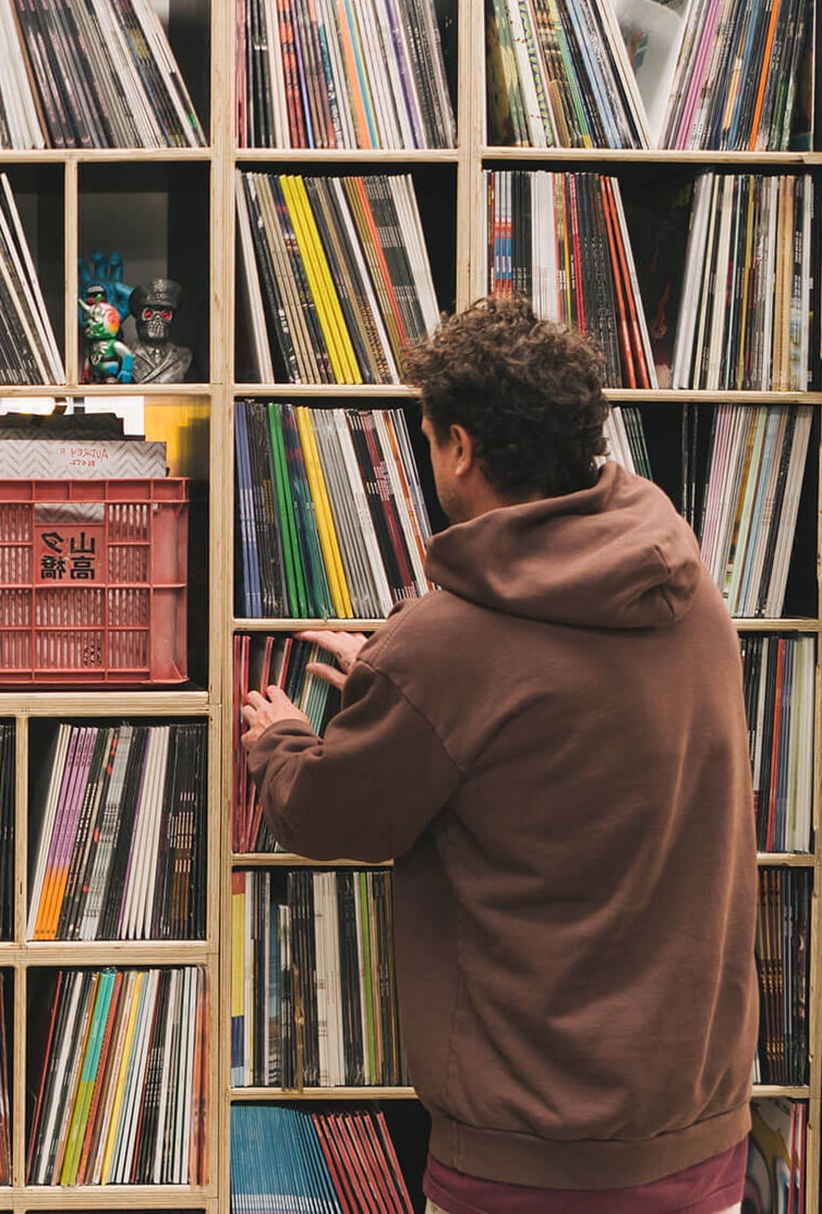 A person browsing shelves of vinyl records at SoundMerch